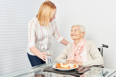 caregiver preparing meal to the senior woman