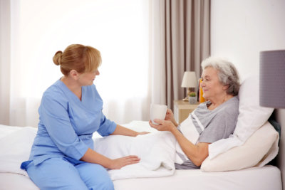 caregiver giving a cup of water to the patient