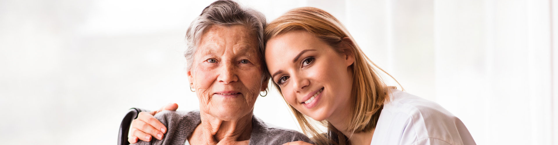 a happy senior woman and a caregiver